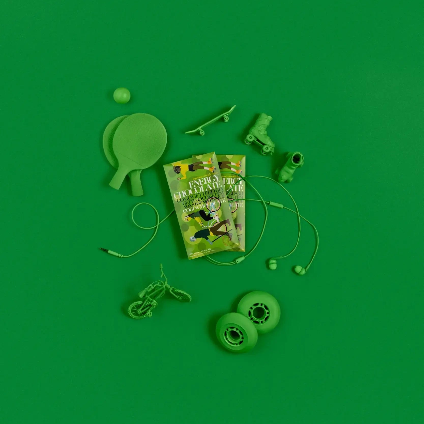 Funco energy chocolate studio green product image with green objects around the product. Like ping pong paddles, headphones, bike, skateboard and skates